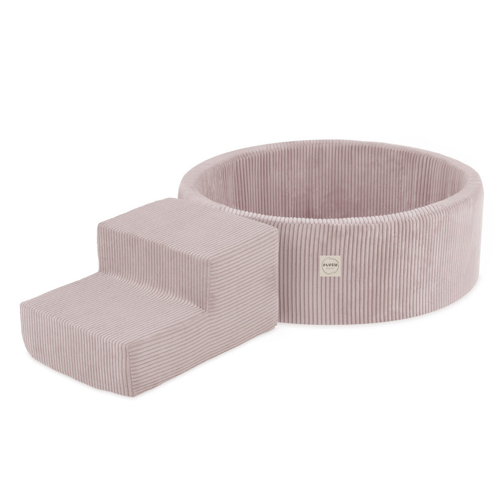 Pliušinis baseinas PLUSH NEST, šviesiai rožinis, vaikas sėdi ant kalnelio – vaizdas 5